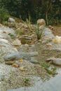 A patak felületének kialakítása szintén az erősített betonos megoldással készült, a kövek, kavicsok természetes benyomást keltenek.